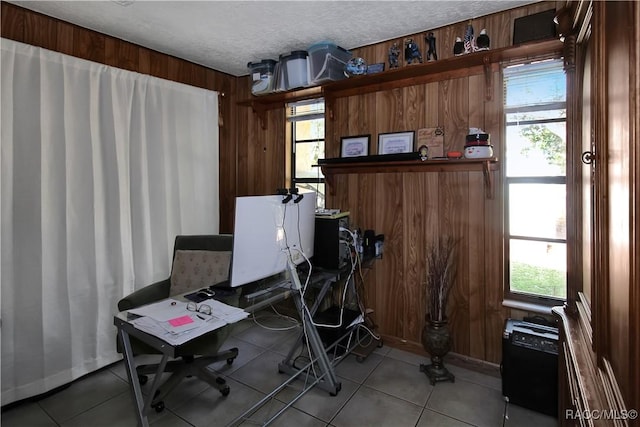 tiled office space with wooden walls, plenty of natural light, and a textured ceiling