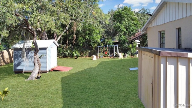 view of yard with a playground and a storage unit