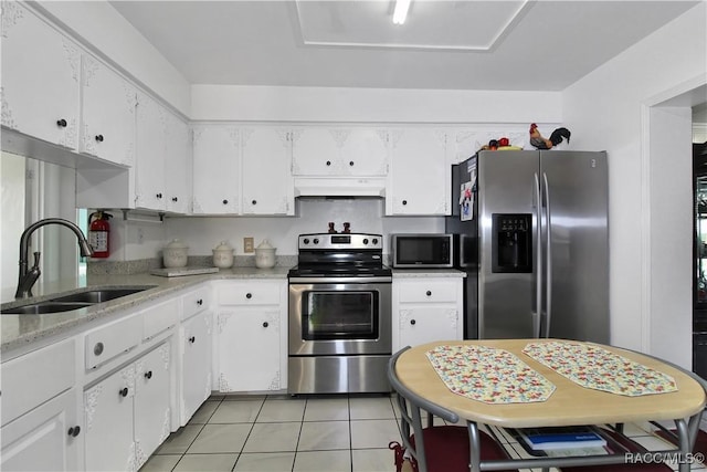 kitchen with sink, white cabinets, light tile patterned floors, custom range hood, and appliances with stainless steel finishes