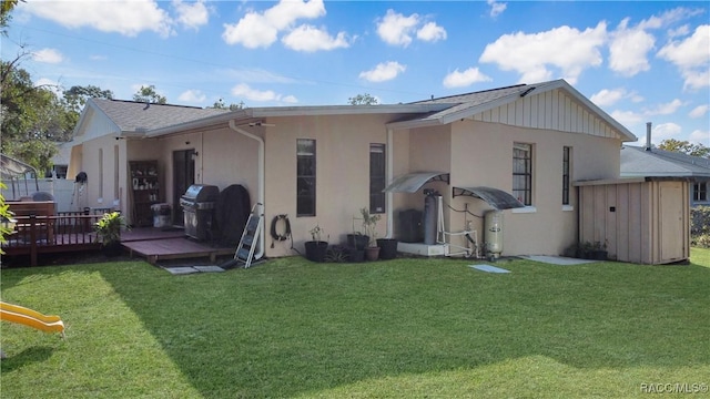 rear view of property featuring a yard and a deck