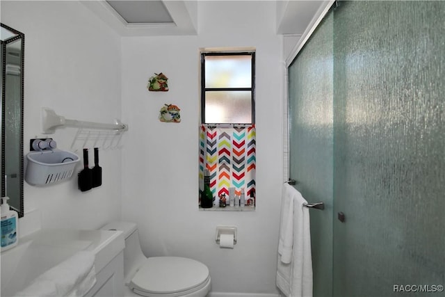 bathroom featuring vanity, toilet, and walk in shower