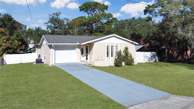 view of front of home with central air condition unit, a front lawn, and a garage