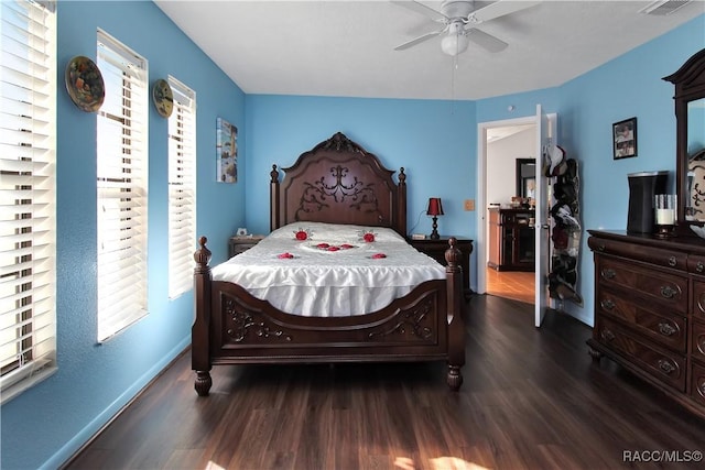 bedroom with ceiling fan, dark hardwood / wood-style flooring, and multiple windows