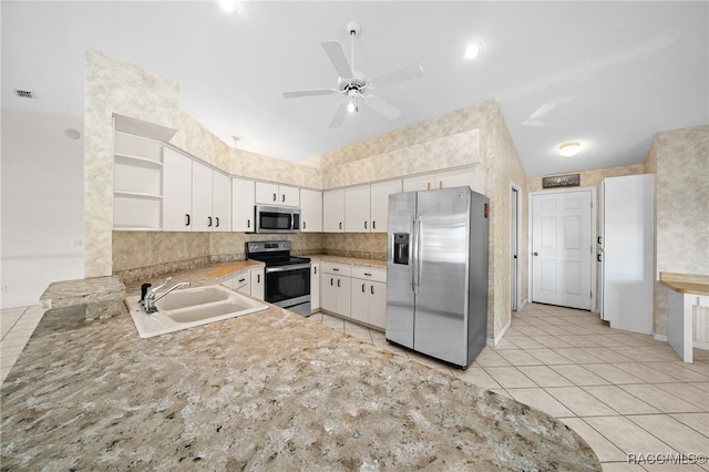 kitchen featuring appliances with stainless steel finishes, ceiling fan, sink, light tile patterned floors, and white cabinets