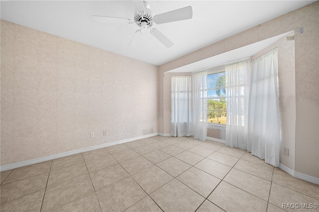 tiled spare room with ceiling fan