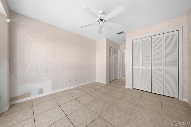 unfurnished bedroom with light tile patterned floors and ceiling fan