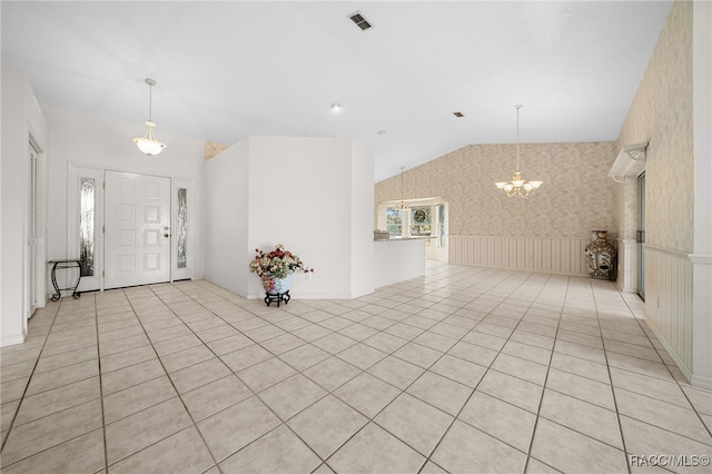 entryway featuring light tile patterned flooring, lofted ceiling, and an inviting chandelier