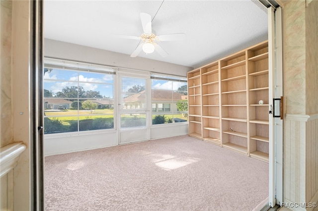 unfurnished sunroom with ceiling fan