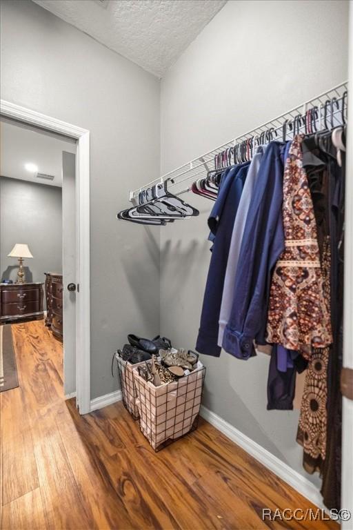 spacious closet featuring visible vents and wood finished floors