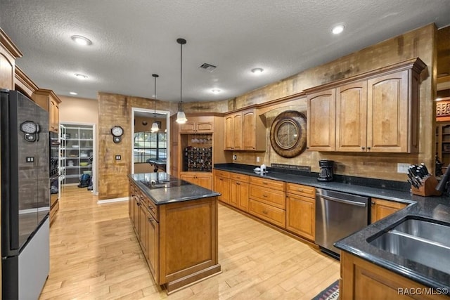 kitchen featuring light wood-type flooring, visible vents, appliances with stainless steel finishes, and a kitchen island