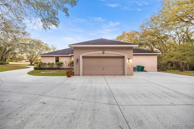 view of front of property with stucco siding, a garage, and driveway