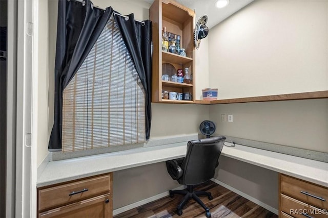 office with dark wood-type flooring and built in study area