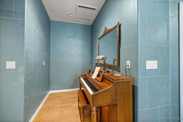 bathroom with tile walls and wood finished floors