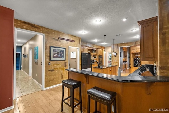 kitchen with dark countertops, a peninsula, a textured ceiling, and fridge