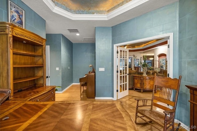 interior space with visible vents, arched walkways, ornamental molding, tile walls, and a raised ceiling