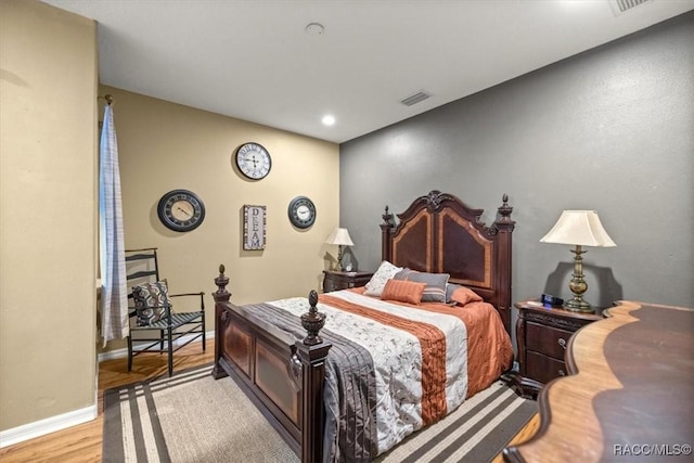 bedroom featuring visible vents, baseboards, and wood finished floors