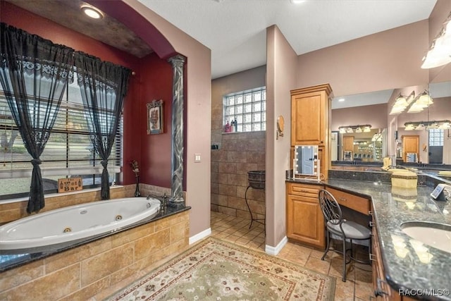 bathroom featuring vanity, baseboards, ornate columns, a whirlpool tub, and walk in shower