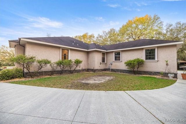 ranch-style home featuring a front yard and stucco siding