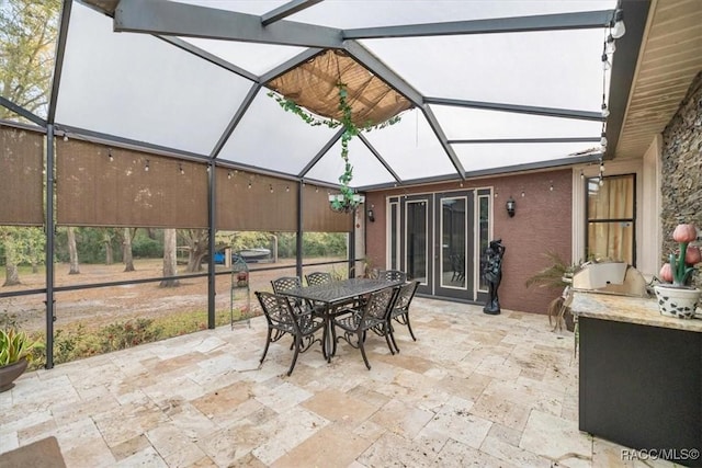 view of patio / terrace with an outdoor kitchen, a lanai, and outdoor dining space