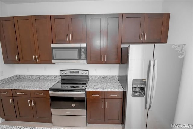 kitchen featuring light stone countertops and stainless steel appliances