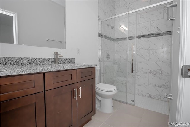 bathroom with tile patterned flooring, vanity, toilet, and walk in shower