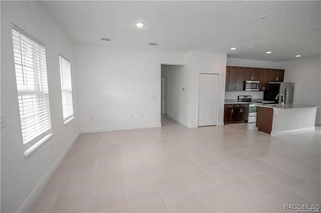 unfurnished living room featuring a healthy amount of sunlight and light tile patterned floors