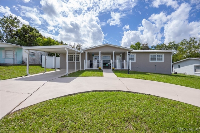 view of front facade with a carport, covered porch, and a front lawn