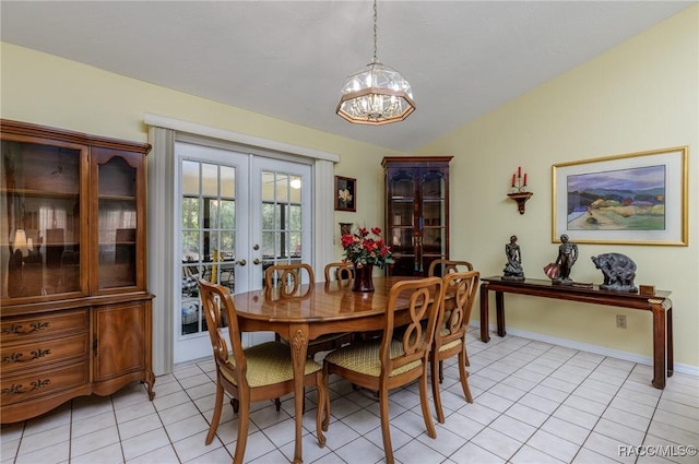 dining space featuring a chandelier, light tile patterned flooring, baseboards, vaulted ceiling, and french doors