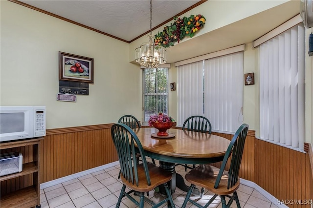 dining room with wainscoting, wood walls, and an inviting chandelier