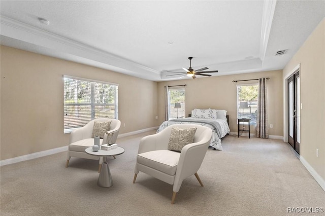 bedroom with a raised ceiling, light carpet, and ceiling fan