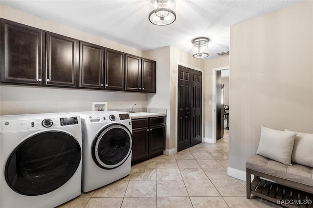 laundry area with independent washer and dryer, cabinets, sink, and light tile patterned floors