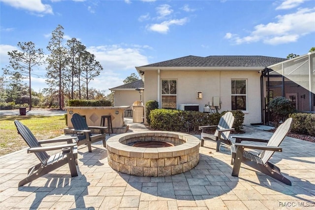 view of patio with a fire pit and glass enclosure