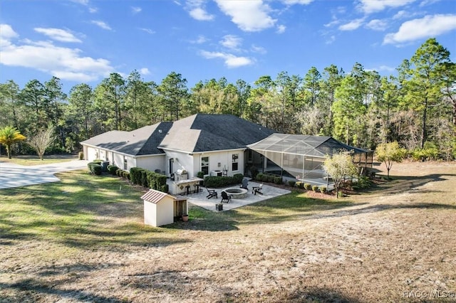 back of property with a lanai, a patio area, and a lawn