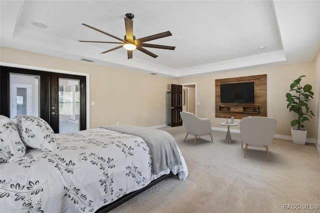 carpeted bedroom with crown molding, ceiling fan, a raised ceiling, and french doors