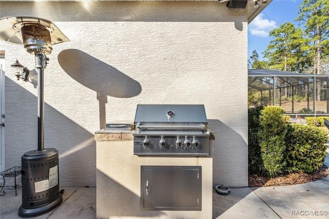 view of patio / terrace featuring a grill, a lanai, and exterior kitchen