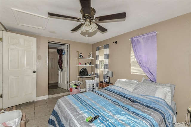 tiled bedroom featuring ceiling fan and a closet