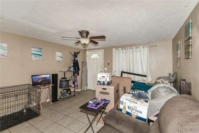 living room featuring a textured ceiling, ceiling fan, and light tile patterned flooring