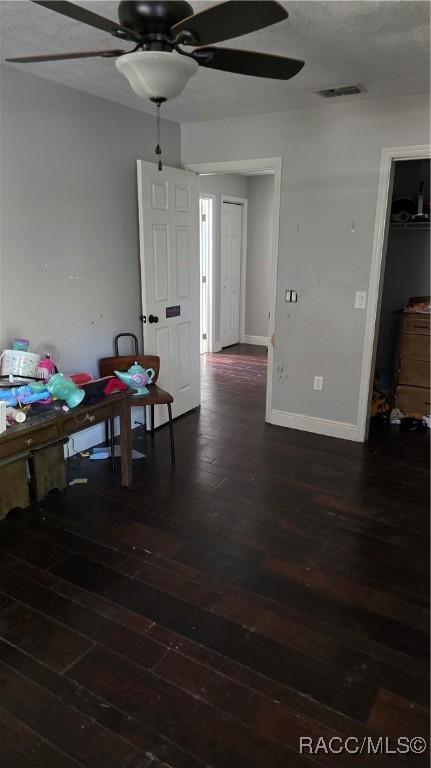 dining area featuring baseboards, visible vents, a ceiling fan, dark wood-style flooring, and a textured ceiling