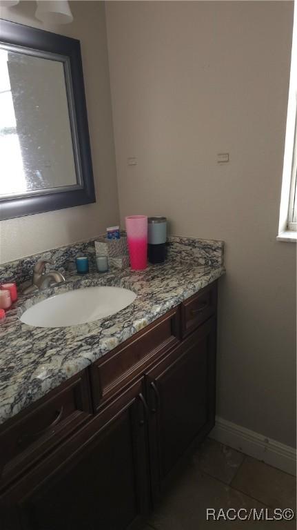 bathroom featuring a wealth of natural light, tile patterned flooring, and vanity