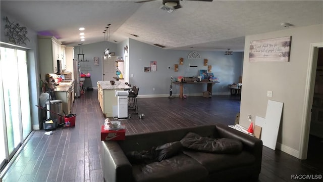 living room featuring visible vents, baseboards, vaulted ceiling, and dark wood-style flooring