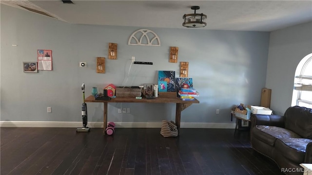 living area with radiator, baseboards, and wood finished floors