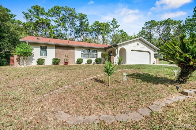 single story home with an attached garage, brick siding, and a front yard