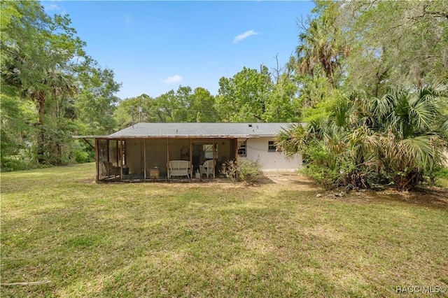 9708 W Hawthorne St, Crystal River, FL 34428 - rear view of house featuring a sunroom and a lawn