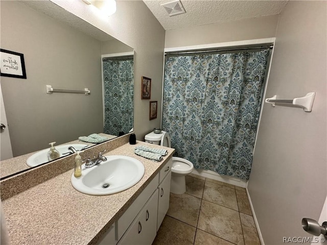 bathroom featuring tile patterned floors, vanity, toilet, and a textured ceiling