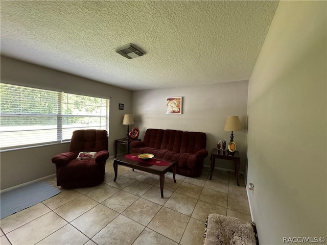 tiled living room featuring a textured ceiling