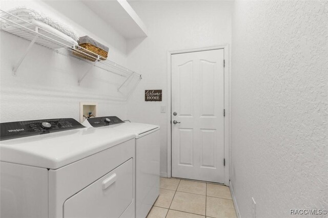 12 Colubrina Ct, Homosassa, FL 34446 - laundry room with washer and clothes dryer, light tile patterned floors, a textured wall, and baseboards