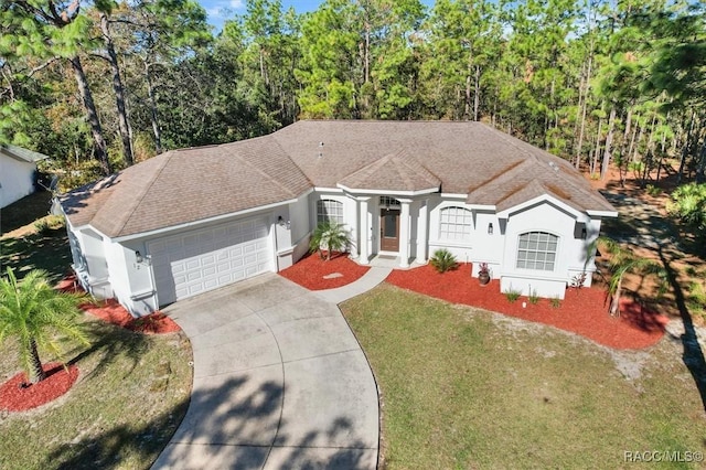 12 Colubrina Ct, Homosassa, FL 34446 - view of front facade featuring stucco siding, an attached garage, driveway, a front yard, and a shingled roof