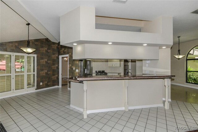 750 NW Snug Harbor Rd, Crystal River, FL 34428 - kitchen featuring stainless steel refrigerator with ice dispenser, light tile patterned floors, decorative light fixtures, and lofted ceiling