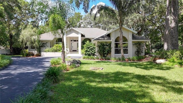 750 NW Snug Harbor Rd, Crystal River, FL 34428 - ranch-style home with stucco siding, driveway, and a front yard