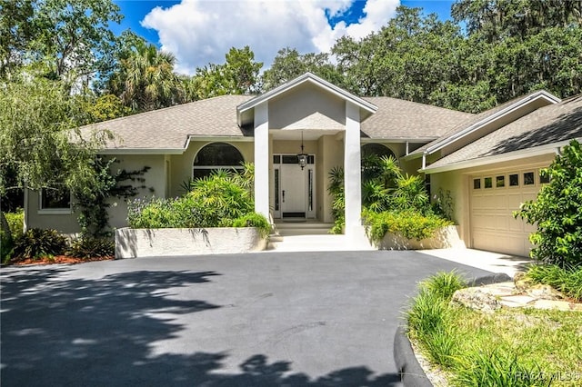 750 NW Snug Harbor Rd, Crystal River, FL 34428 - single story home with a garage, stucco siding, asphalt driveway, and roof with shingles
